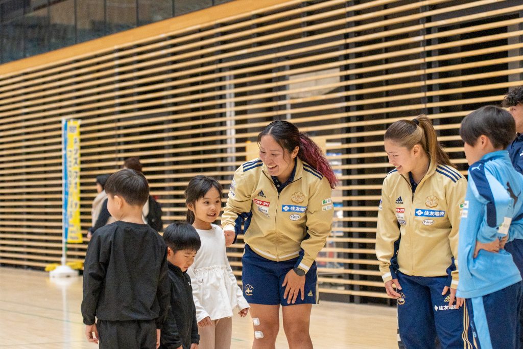 四日市アリーナで女子ラグビーチームPEARLSの選手が子どもに優しく声をかけている様子｜MiRAI主催のスポーツ体験イベント