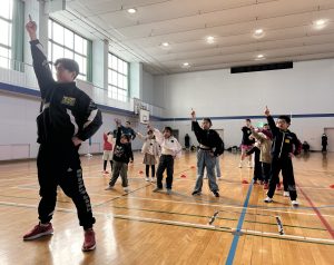 きむ先生とダンスイベントに参加した子どもたちが、笑顔で決めポーズをしている様子