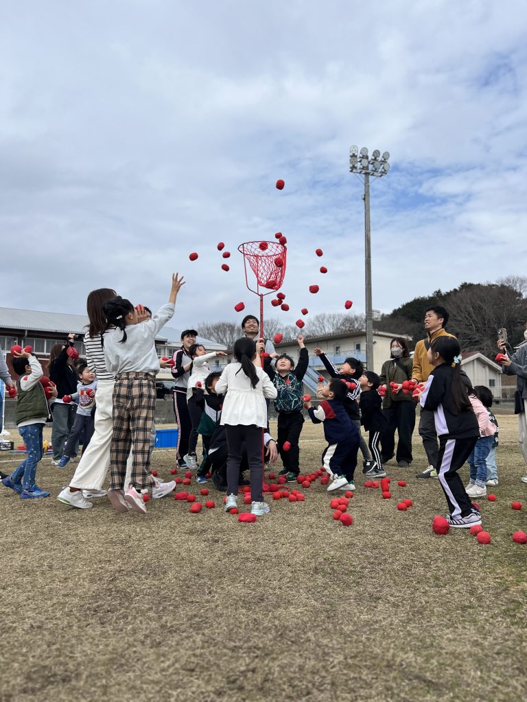 四日市の運動会イベントで親子が玉入れに挑戦し、笑顔で玉を投げ入れている様子