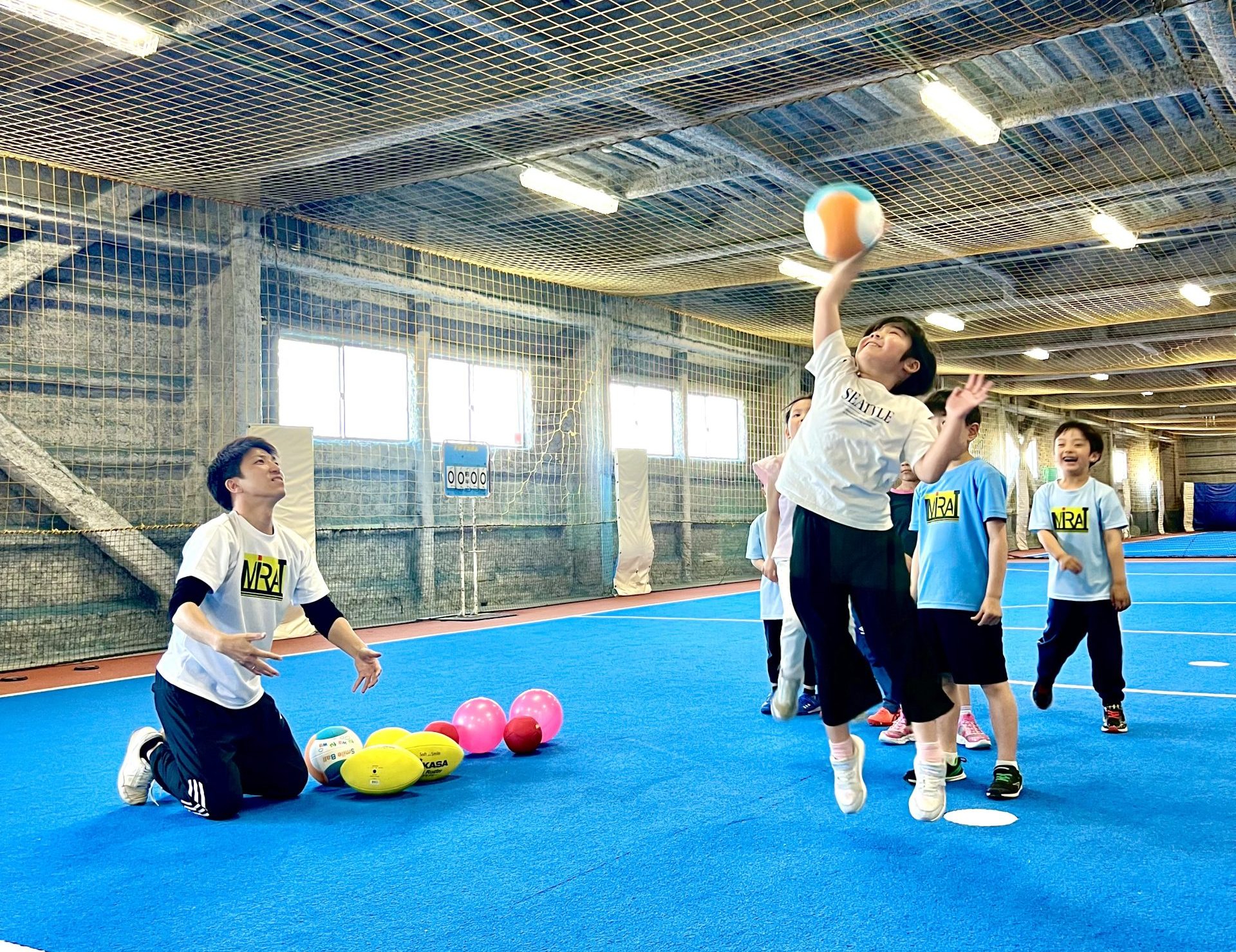 四日市・菰野の子ども向け習い事MiRAIで、けいた先生がトスしたボールを体験に来てくれた子がスマッシュしている運動シーン