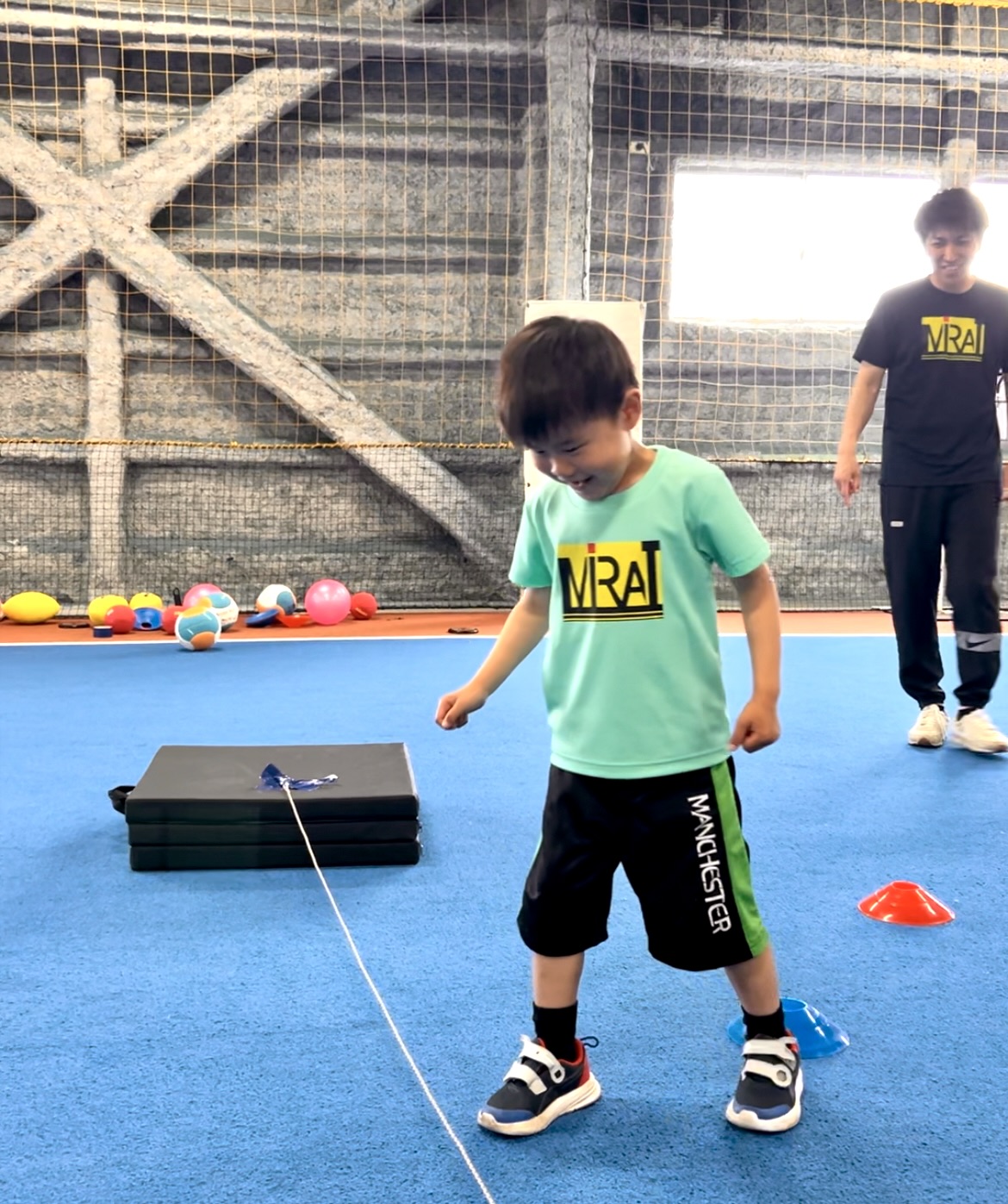 四日市市の体育スクールMiRAIで、初めて走り幅跳びに挑戦する未就学児の真剣な表情