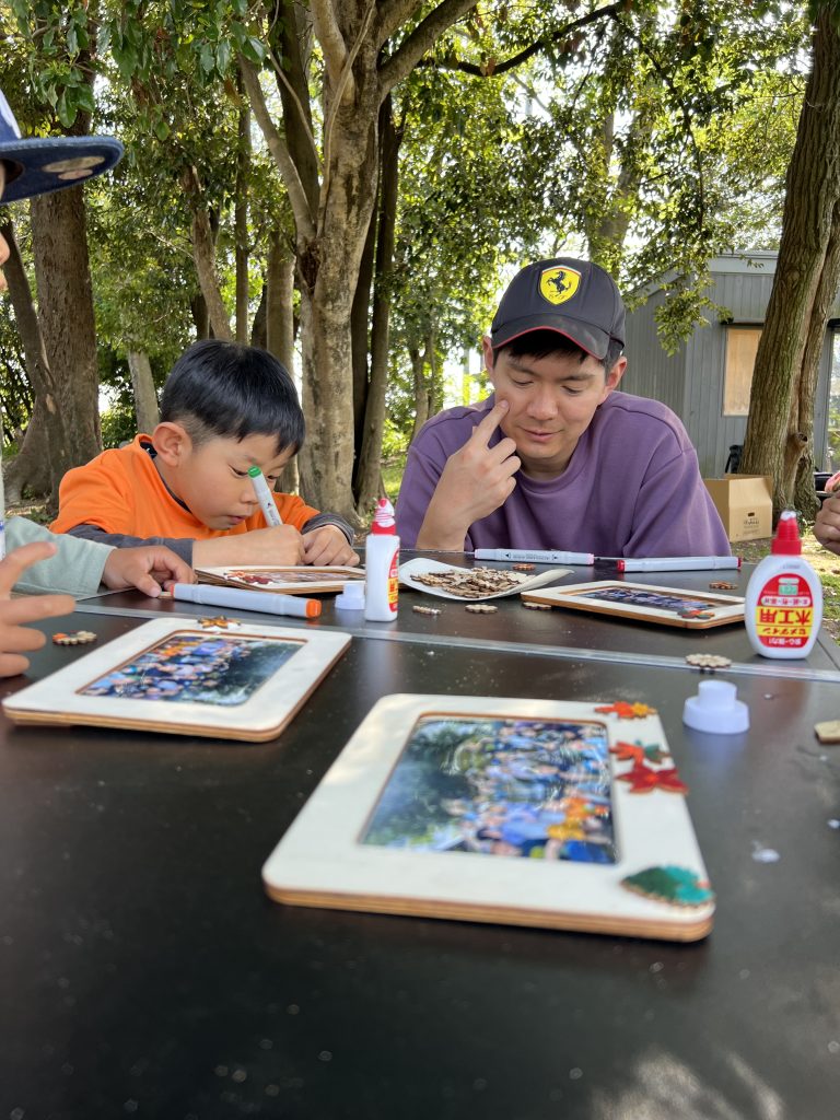 MiRAIヒミツ基地デイキャンプで、子どもたちが真剣にフォトフレームを創作し、思い出の集合写真を貼って完成させている様子。四日市・菰野町を拠点とした子ども向け体験型習い事の一場面。