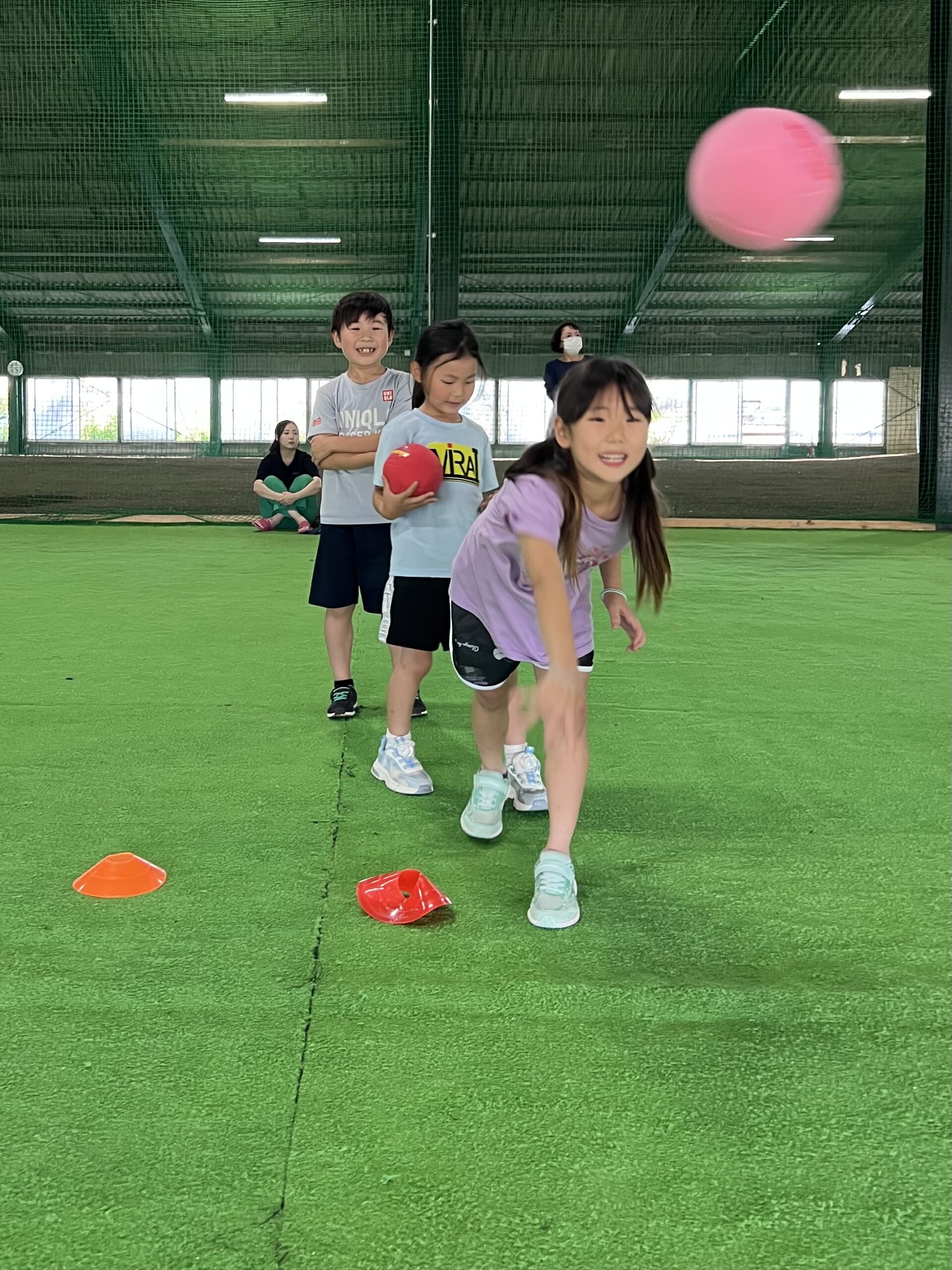 小学校1年生の女の子がハンドボールを力強くゴールに投げている様子