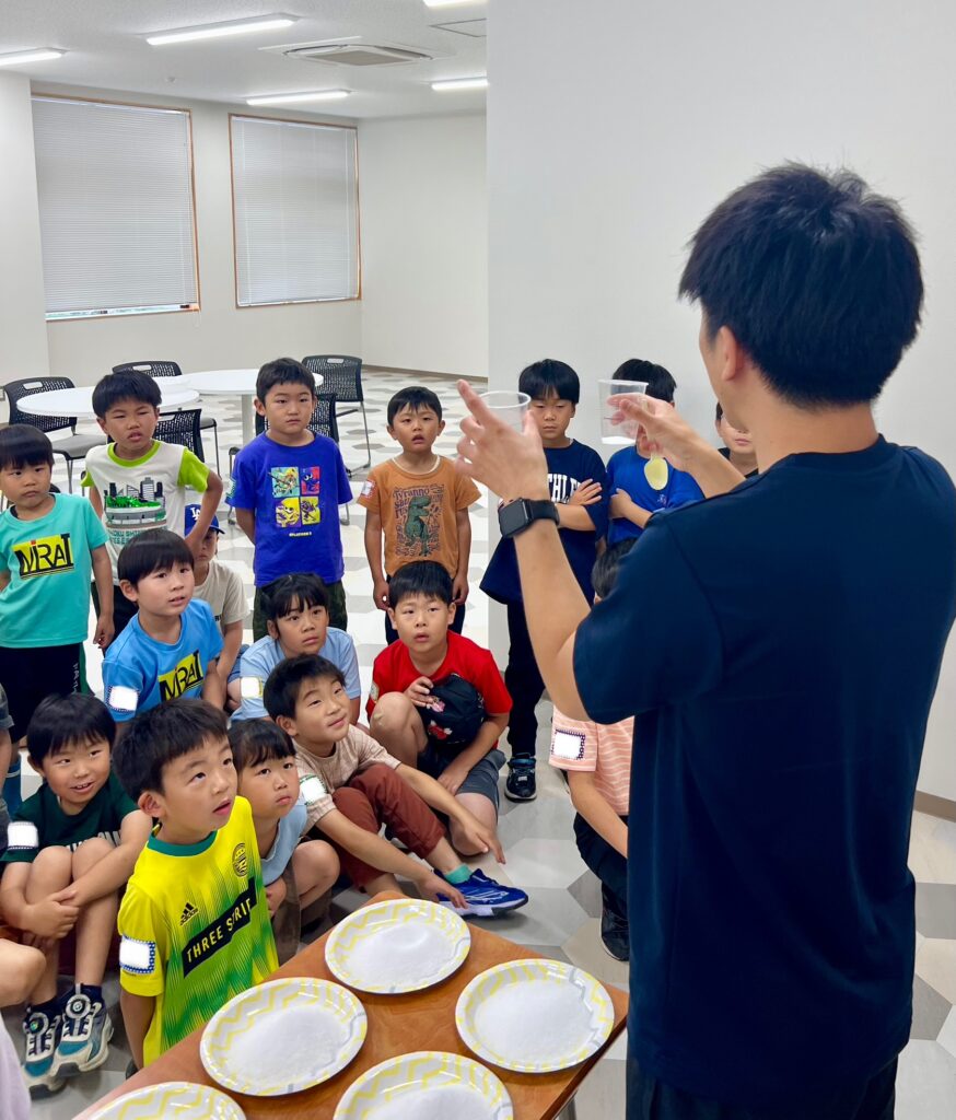 四日市の小学生たちがけいた先生の泡の爆発実験の解説を夢中で聞く様子（科学教室・子ども・習い事）