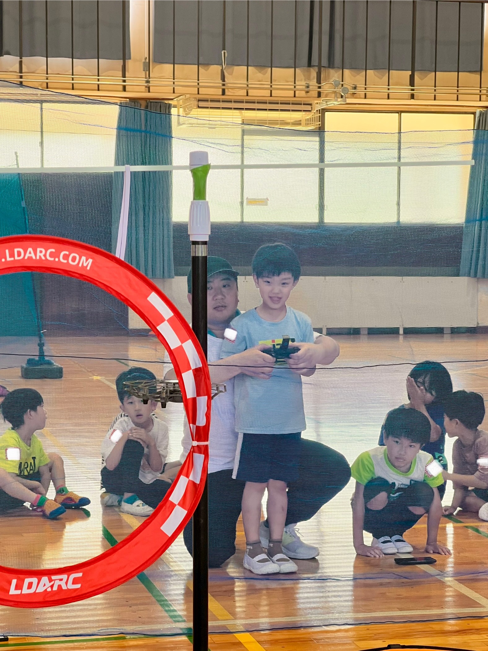 MiRAIドローン体験イベントで、ターゲット通過の操縦ミッションに挑戦する小学生の様子（三重県四日市市・メリノール学院）