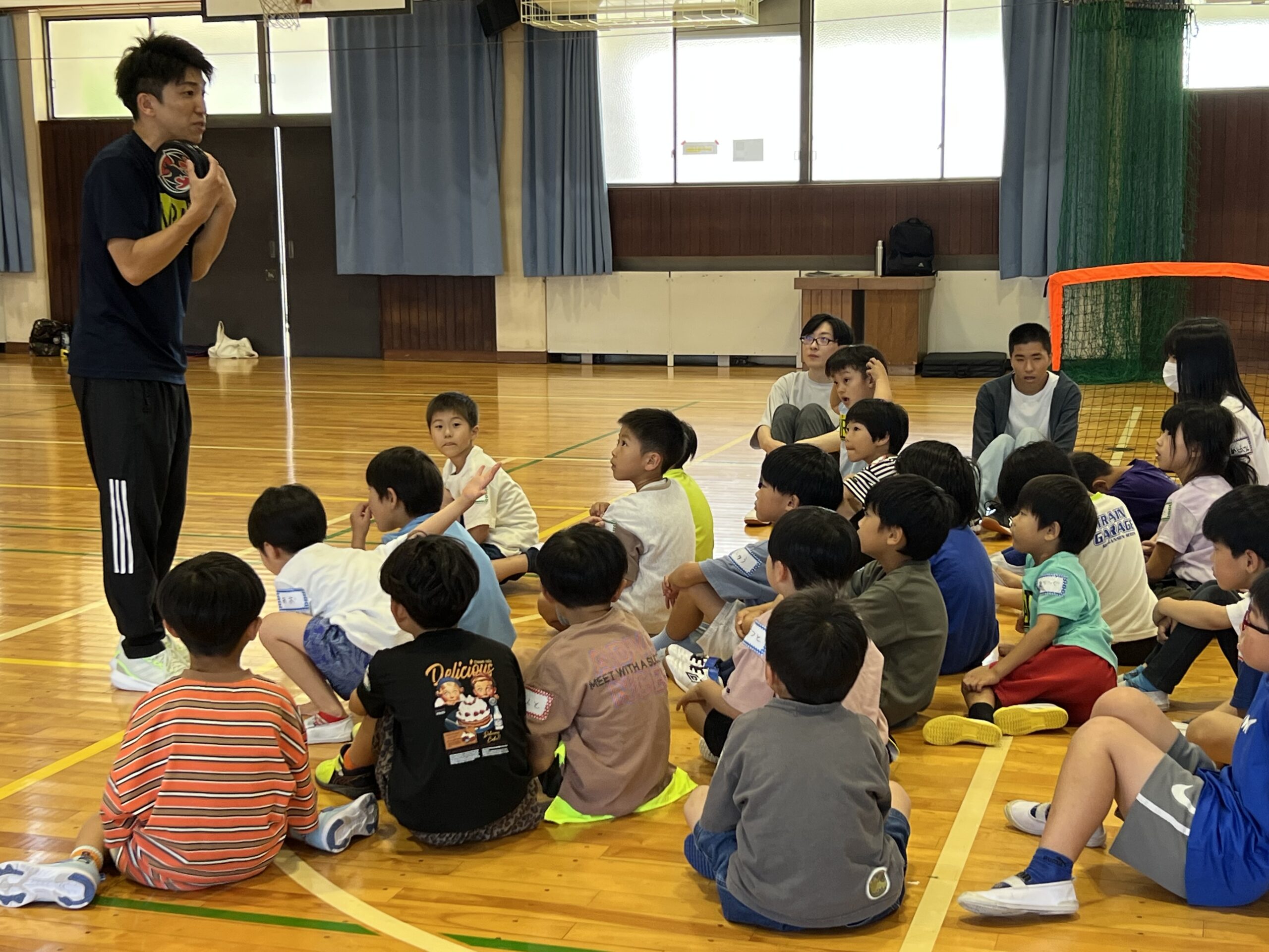 MiRAIのイベントで、けいた先生が子どもたちにスポーツ体験の内容を説明している様子（三重県四日市市）