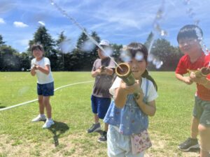 四日市のミライ主催サマスクで、子どもたちが自分で作った竹の水鉄砲を笑顔で発射しながら夏休みを満喫している様子