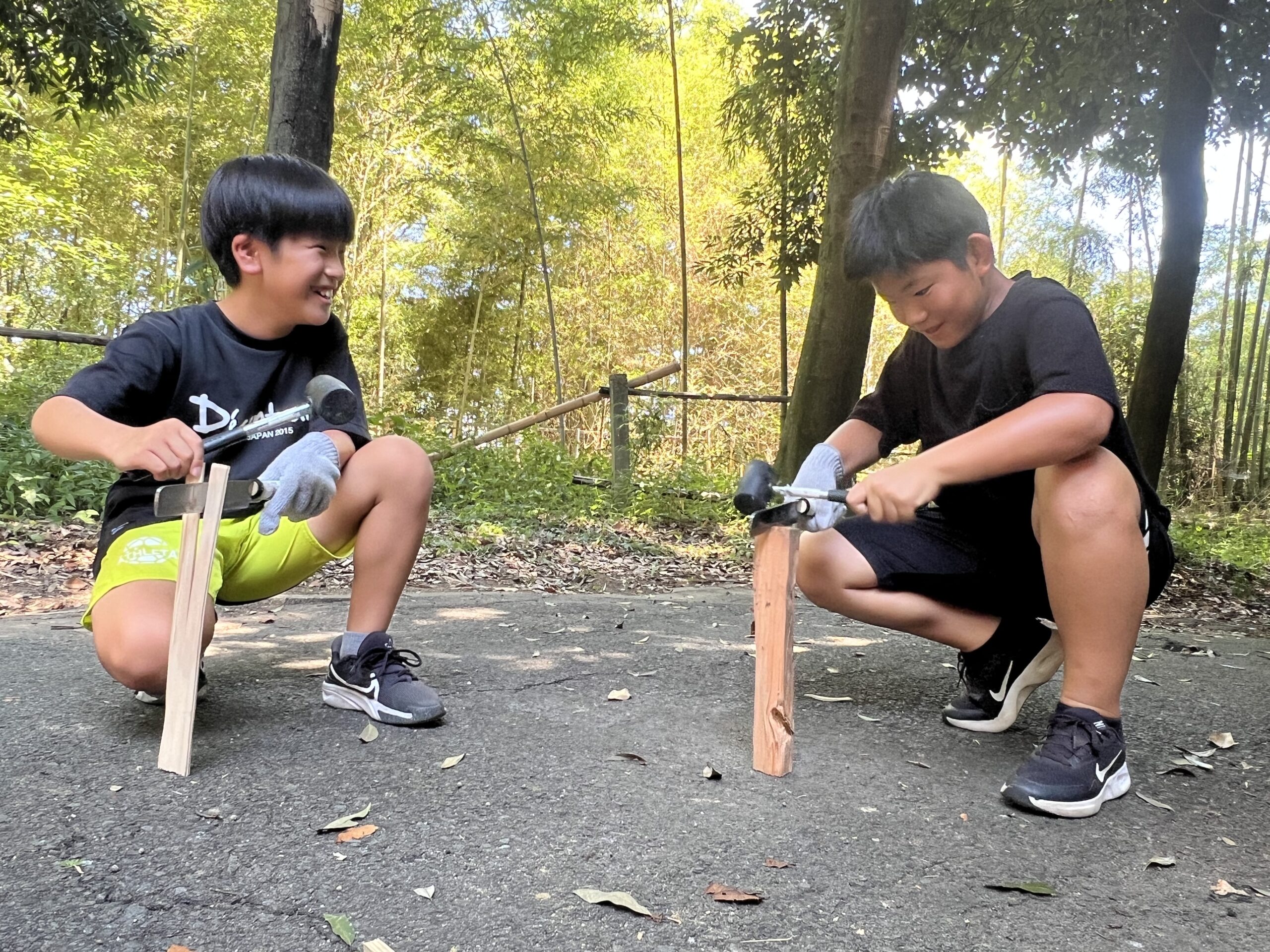 四日市で開催されたMiRAIサマスクで、子どもが初めてナタとハンマーを使い、まき割りに挑戦している様子。夏休みの特別な自然体験を通じて、挑戦する心と自信を育んでいる瞬間。