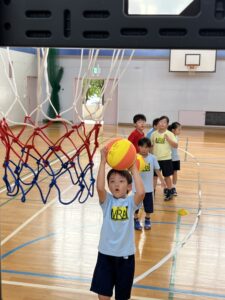 四日市・菰野町エリアの小学生が、総合スポーツスクールMiRAIの体験会でバスケットボールをシュートする瞬間の様子