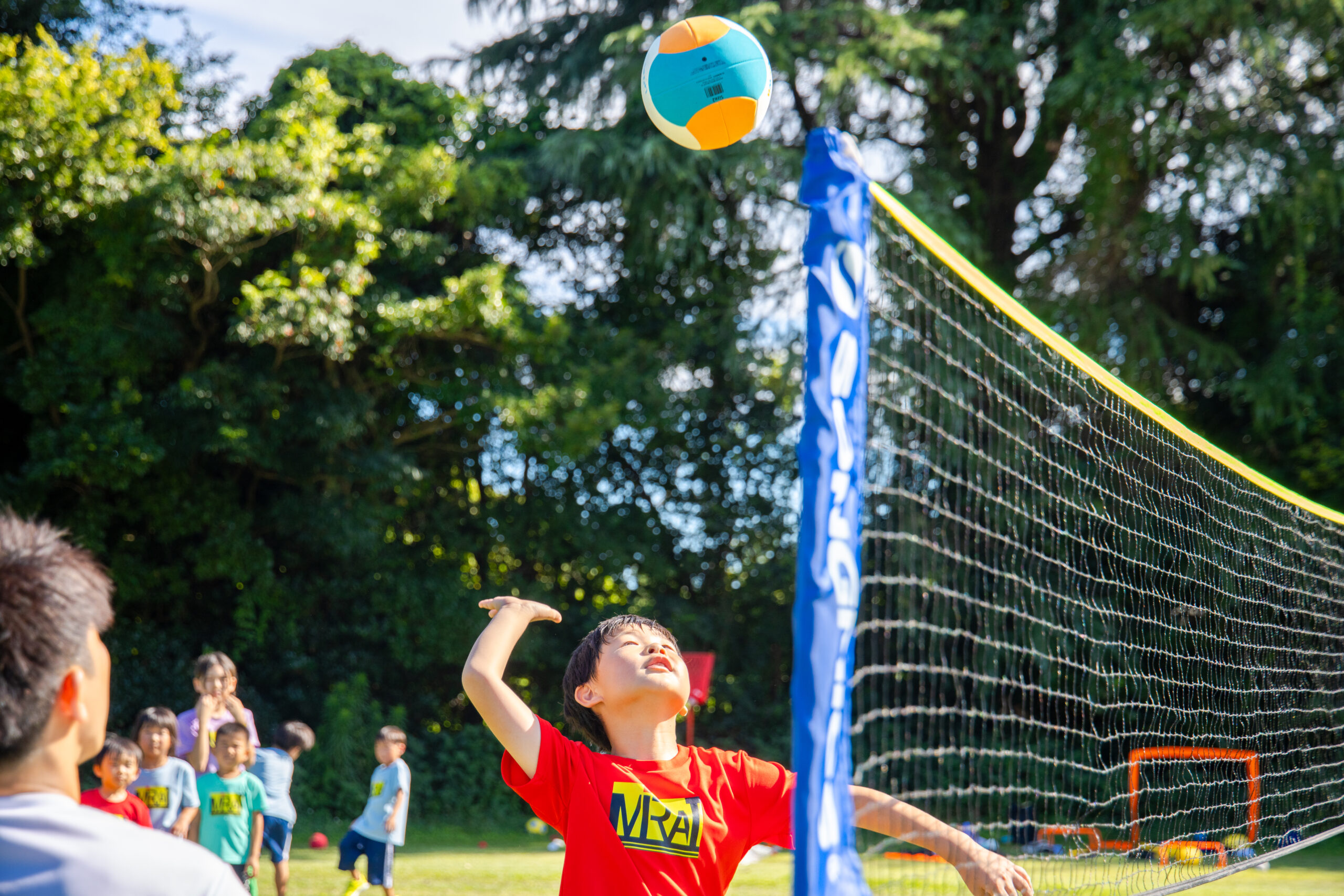 三重県四日市市の小学生がスポーツスクールMiRAIでネット型スポーツに挑戦し、バレーボールをスマッシュする瞬間