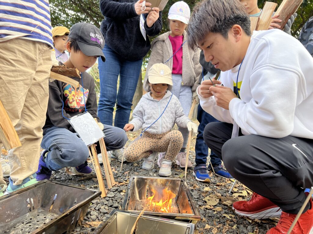 年中〜小6対象】三重県北勢（四日市市・菰野町）の習い事。総合スポーツスクールMiRAIのキャンプで、子どもたちが思考力を使って火おこしに挑戦している様子。
