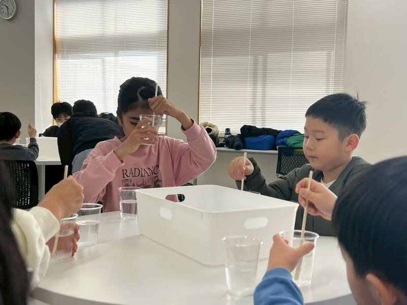 総合スポーツスクールMiRAIの科学教室で、重曹とクエン酸を使った化学反応の実験に取り組む子どもたち