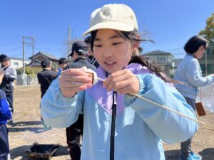 菰野町の野外体験でマシュマロを焼いて楽しむ女の子の様子